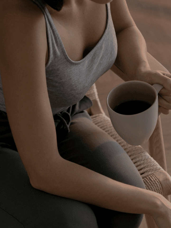 Seorang perempuan duduk memegang mug setelah selesai menjalani pemeriksaan dan kembali beraktivitas
