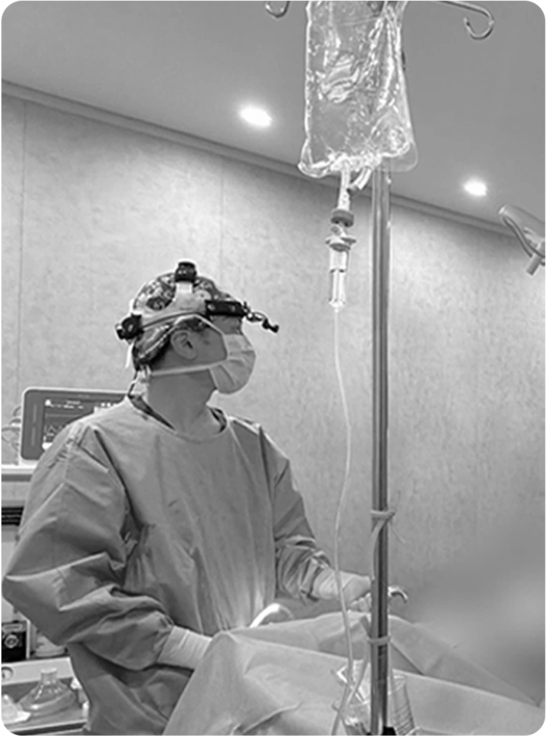 Foto hitam putih dokter bedah yang sedang mempersiapkan operasi